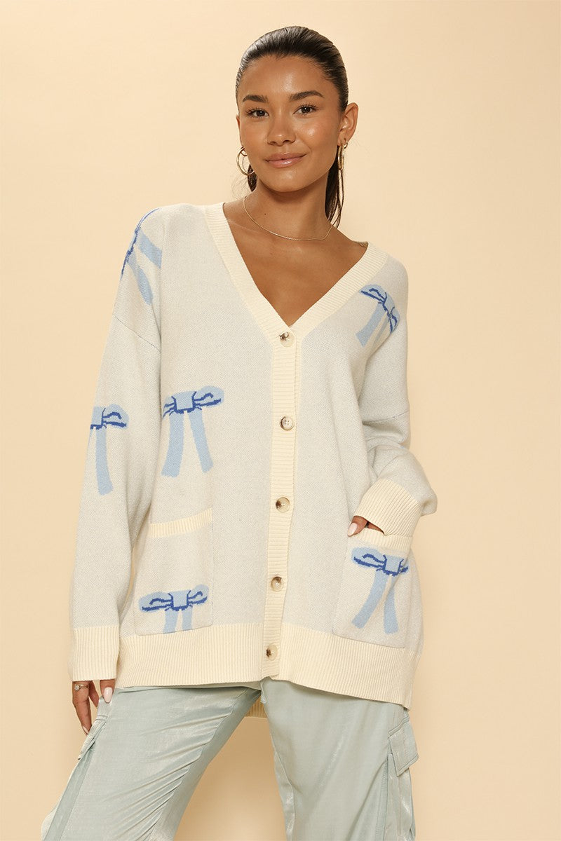All Over Bow Knit Cardigan. Oversized V-Neck, Button Front & Pockets