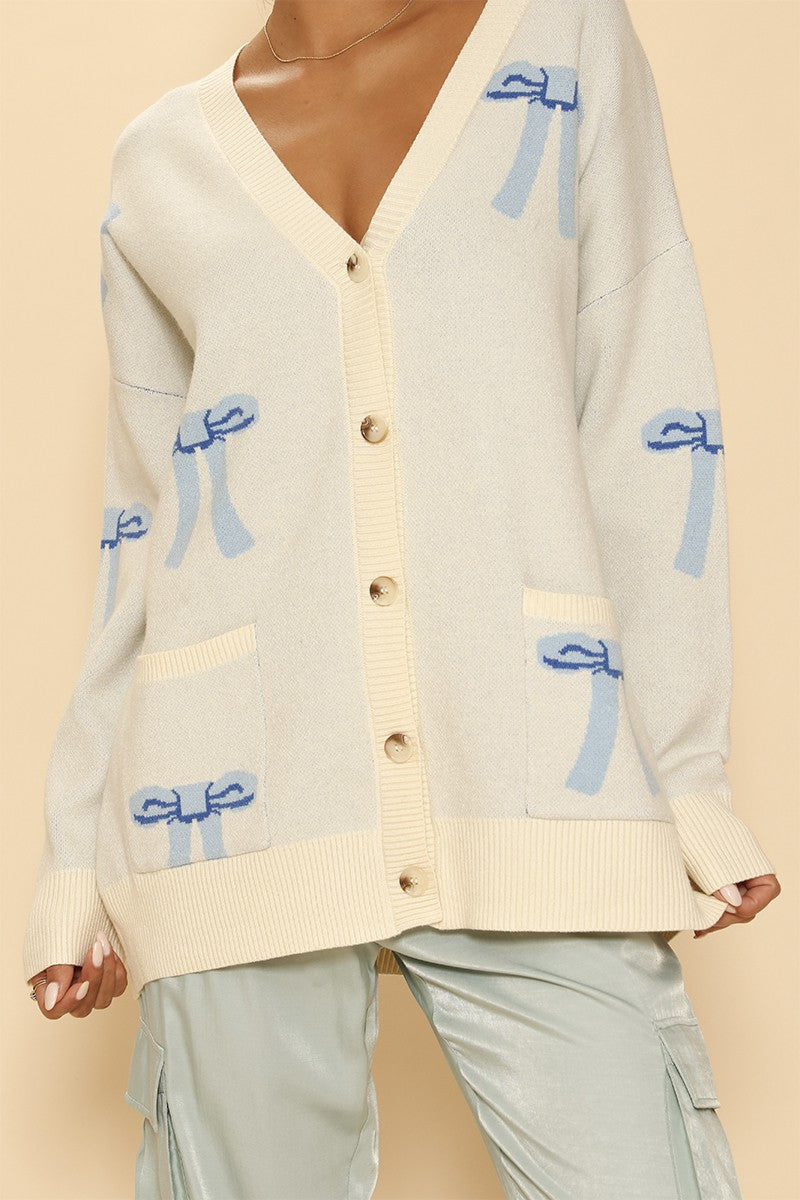All Over Bow Knit Cardigan. Oversized V-Neck, Button Front & Pockets