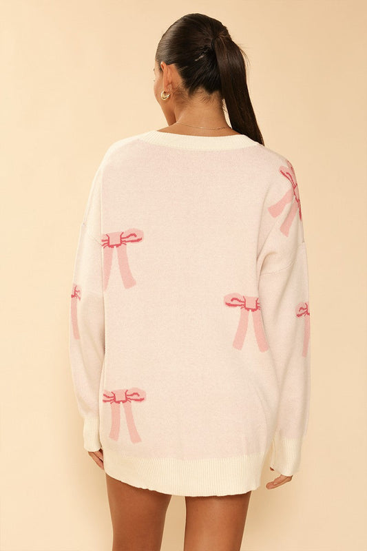 All Over Bow Knit Cardigan. Oversized V-Neck, Button Front & Pockets