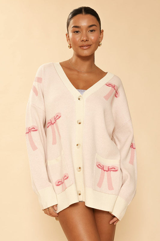 All Over Bow Knit Cardigan. Oversized V-Neck, Button Front & Pockets